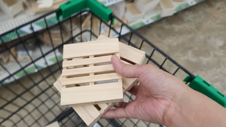 Person putting Dollar Tree mini pallets in a shopping cart