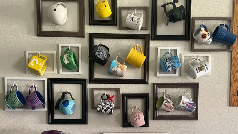 Mugs hanging from hooks inside frames