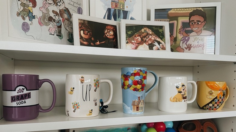 Cups lined on a shelf below pictures