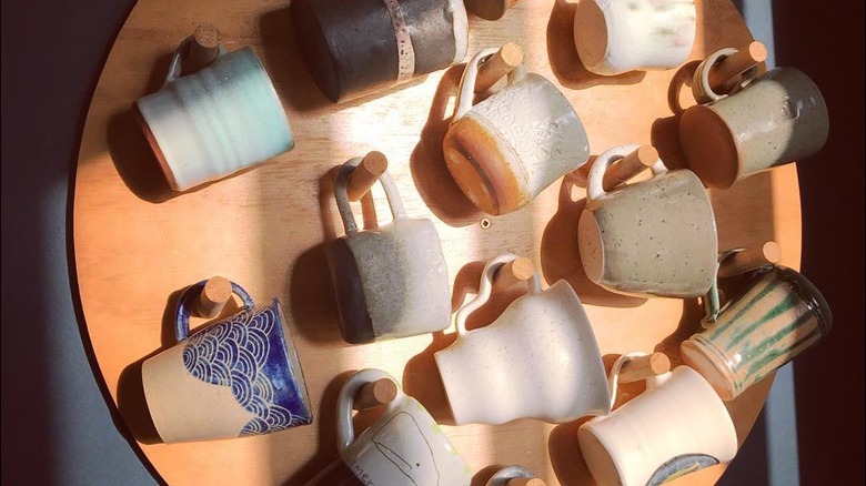 Colorful mugs on a wooden round