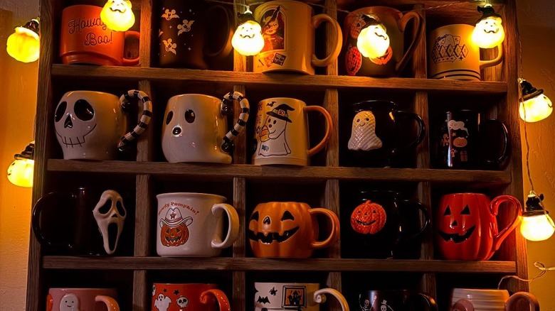 Spooky mugs on a wooden shelf
