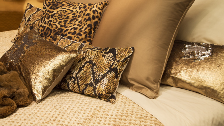 Animal print pillows on a bed.