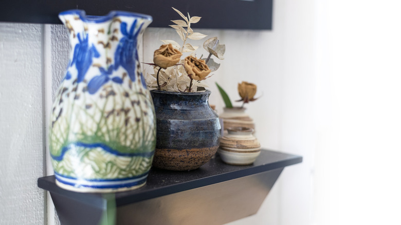 Pottery pieces adorn a small wall-mounted shelf.