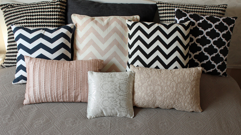 An assortment of modern printed pillows on a couch.