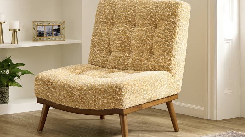 Low, wide-seated, cream-colored upholstered chair in a living room