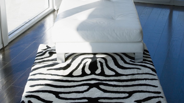 A zebra print rug under a white chair.