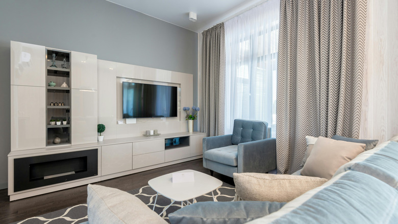 A large white entertainment center next to a window.