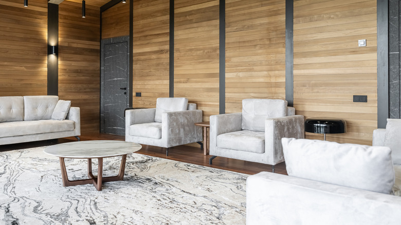 matching ash furniture set in living room with wood panels