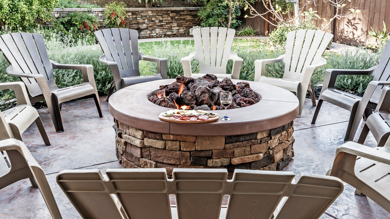 chairs around stone fire pit 