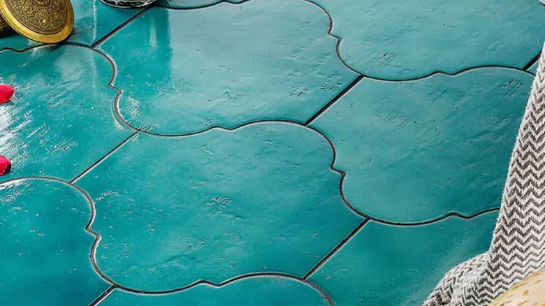 Bright teal arabesque tiles with dark grout