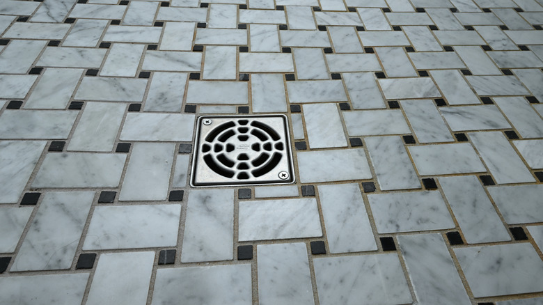 Basketweave tile with white marble and black pieces on the floor in a shower