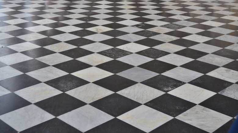 An expansive checkerboard floor with black and white square tiles on a diagonal