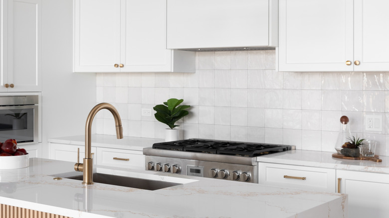 White square tiles placed as kitchen backsplash behind the stove