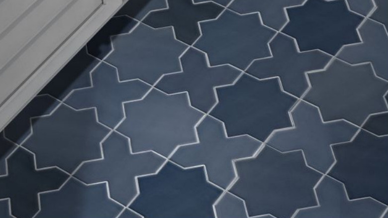 Dark blue star and cross tile on the ground in front of a cabinet with white grout
