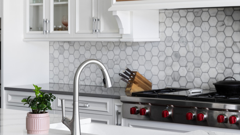 Marble hexagon tile backsplash in a kitchen wall behind a stove