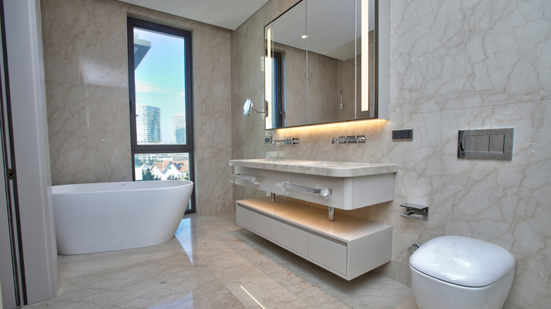 A bathroom completely covered on the walls and floor with the same large pattered tiles.