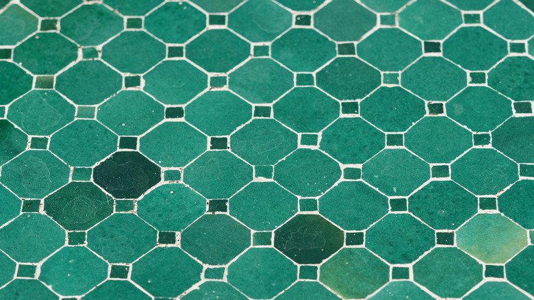 Green octagon tiles in different shades of green with small square tiles in between on the shorter edges.