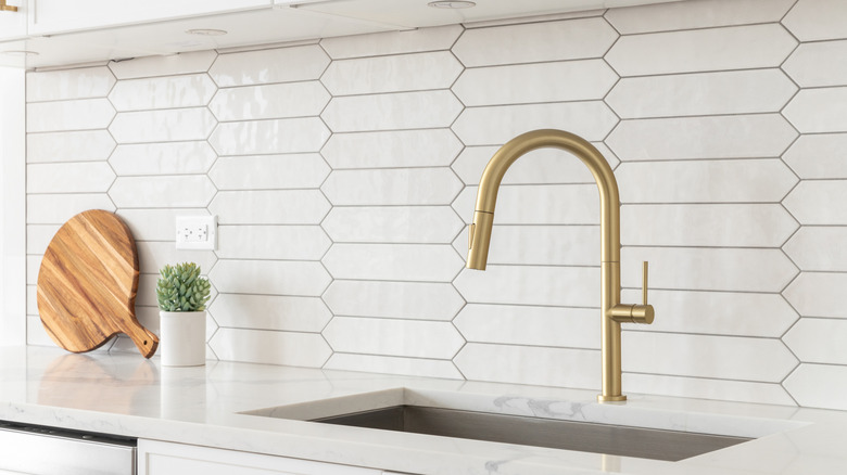 A kitchen backsplash made of white picket tiles stacked vertically