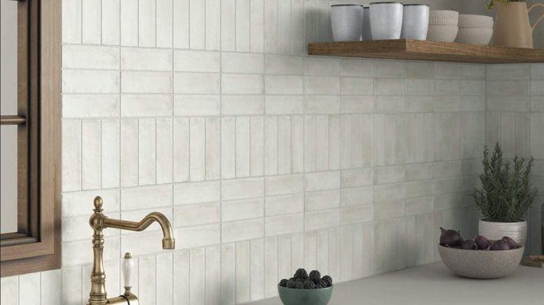 A kitchen with a series of subway tiles, some are horizontal and some are vertical
