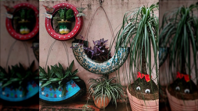 Painted tires used as hanging wall planters.