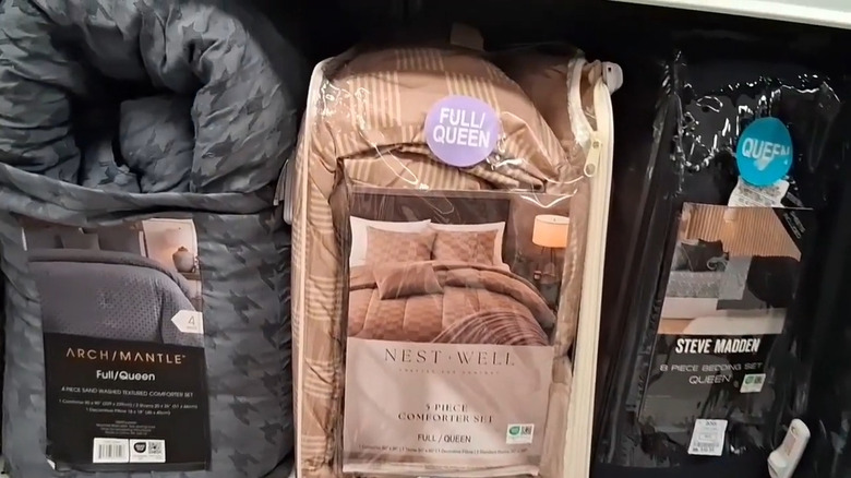 Three packaged full/queen bedspreads in a Ross store