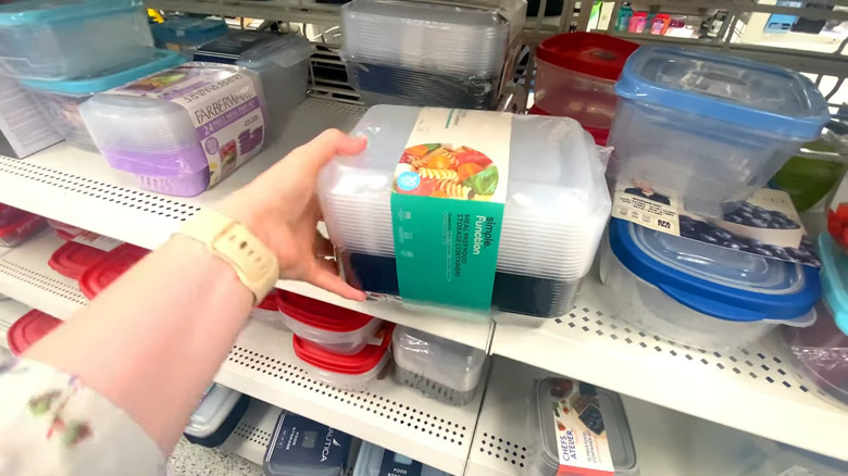Reaching for plastic food store containers from a shelf