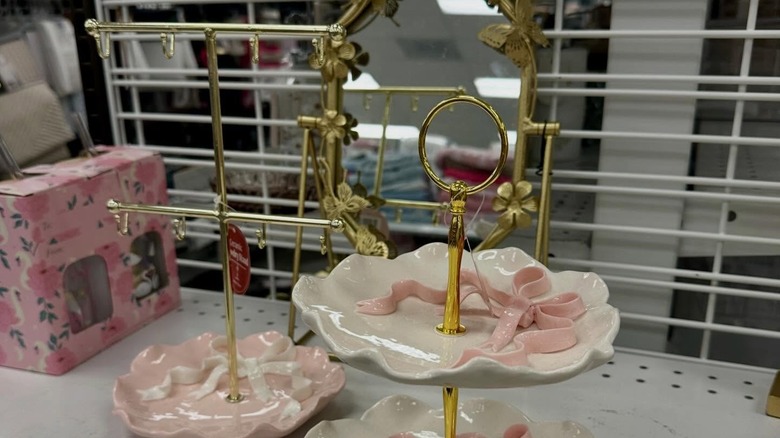 Gold and ribbon accented tiered jewelry try on a shelf