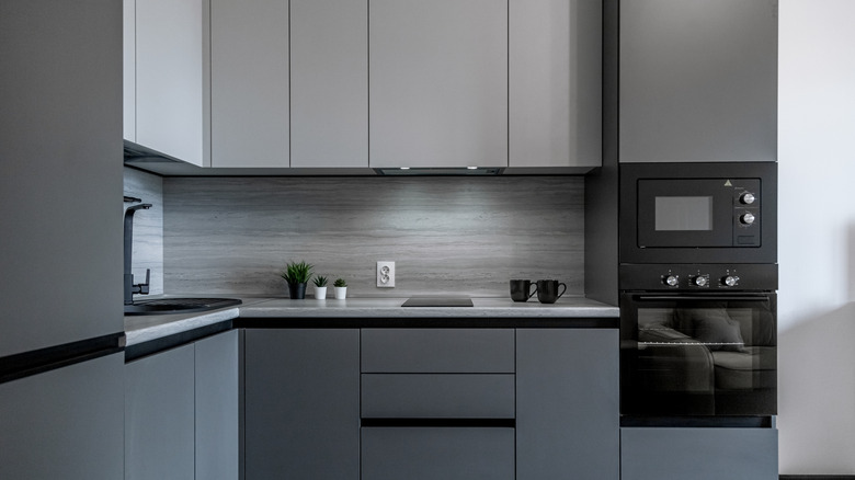 Granite backsplash complementing dark cabinets in different shades of gray.