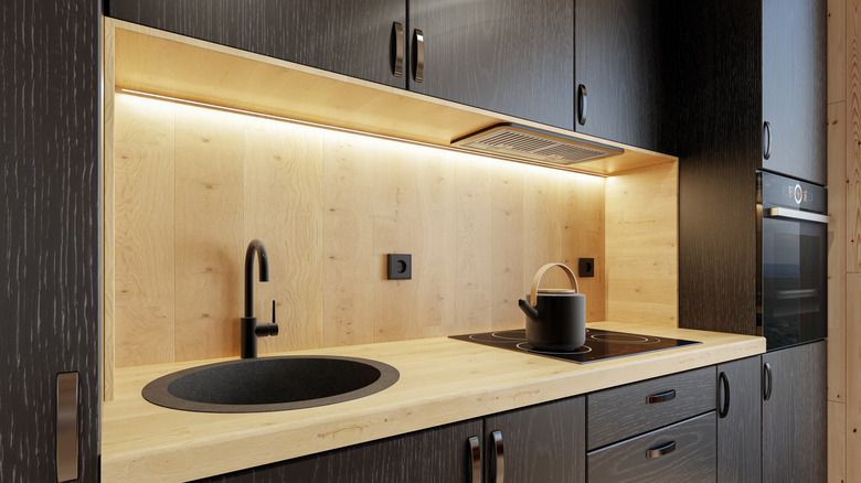 Natural pine wood backsplash matching the countertop, set against dark wood-finish cabinets.