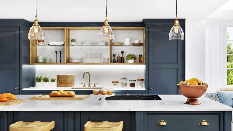 Onyx as backsplash and extended wall with glass and wood top shelving and dark blue cabinets with gold accents.