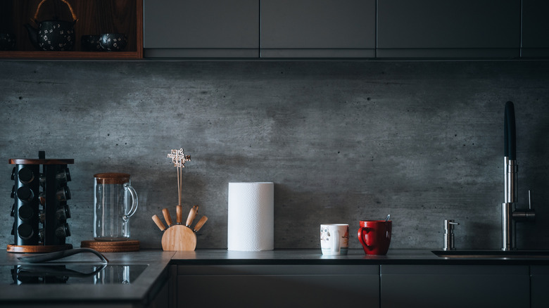 Concrete backsplash and dark countertop and cabinets.