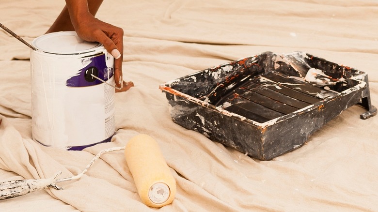 person opening can of paint