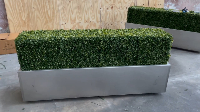 a diy artificial hedge can be used to hide ugly electrical eyesores in your yard