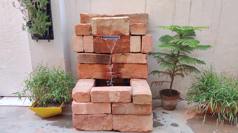a simple water feature constructed of bricks could be placed in front of an electrical eyesore to hide it from view