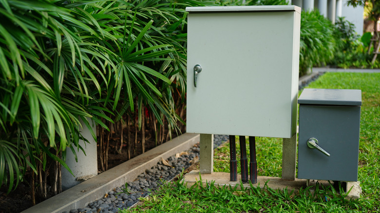 neatly installed electrical boxes still stick out like a sore thumb in a front yard landscape