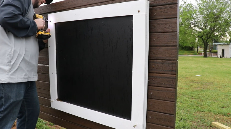 a man makes an outdoor chalkboard on a panel