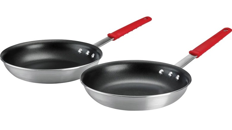 Frying pans on stove cooking omelette