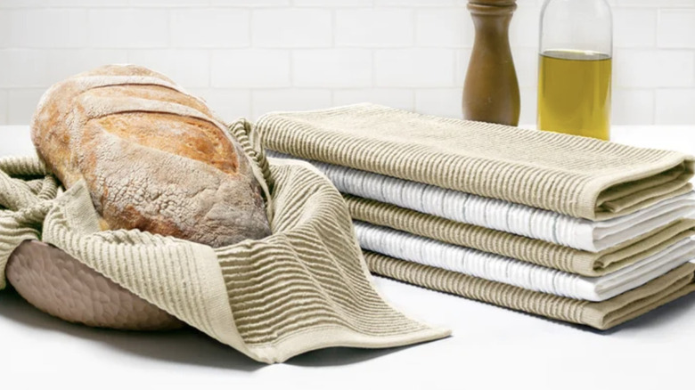 Beige and white towels in kitchen with loaf of bread