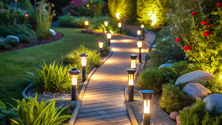 Solar lights illuminate a garden path at night.