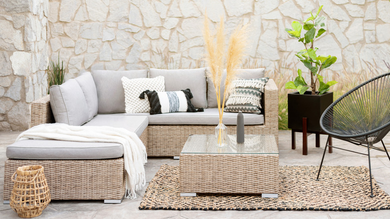 Gray patio furniture against a white decorative stone wall