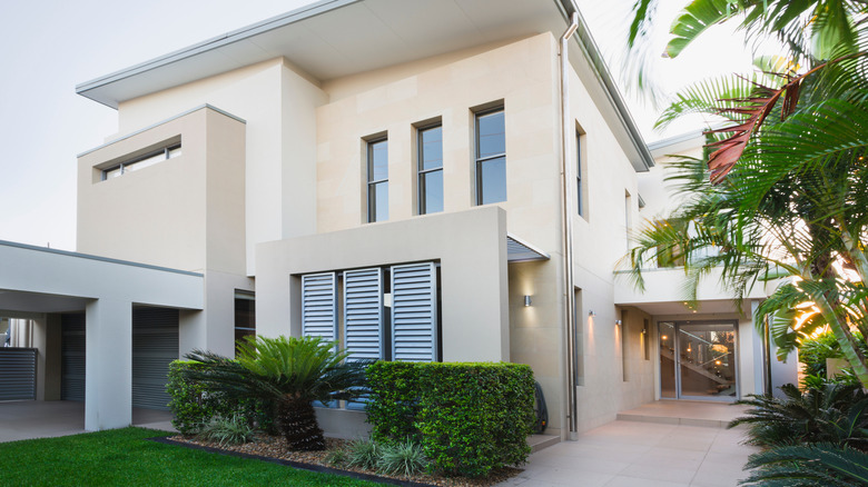 A modern duplex with plants growing in the front yard
