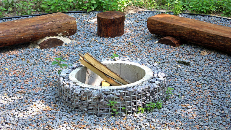 A small round handmade fire pit surrounded by wooden benches