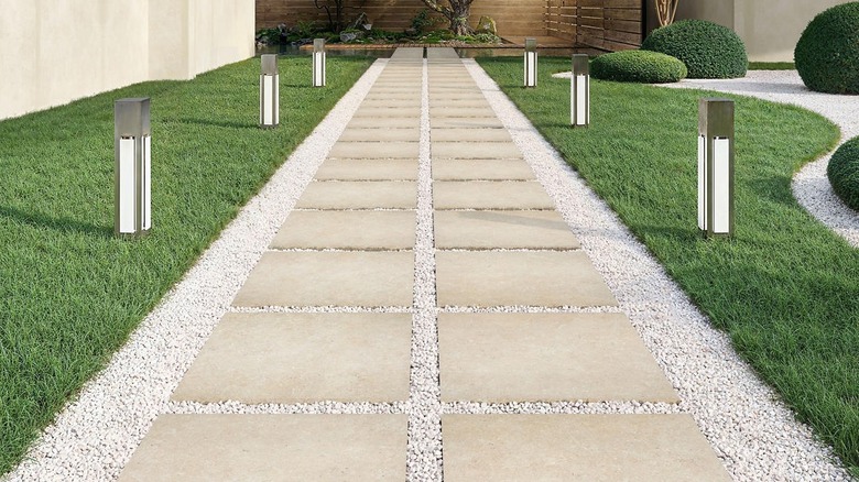 Stone-like tile pavers surrounded by grass on either side