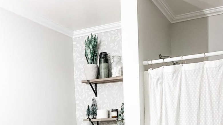 A white bathroom with white crown molding at ceiling.