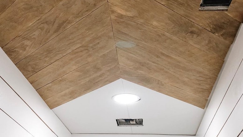 Wood herringbone ceilings next to white walls.