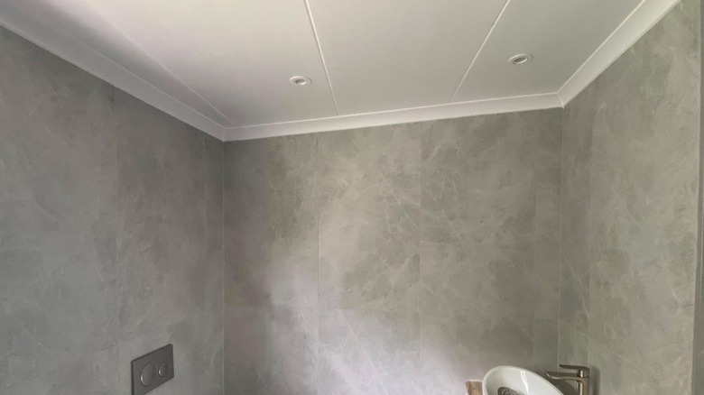A bathroom ceiling with large white panels.