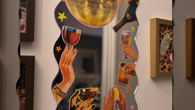 A mirror adorned with cutouts on a wall.