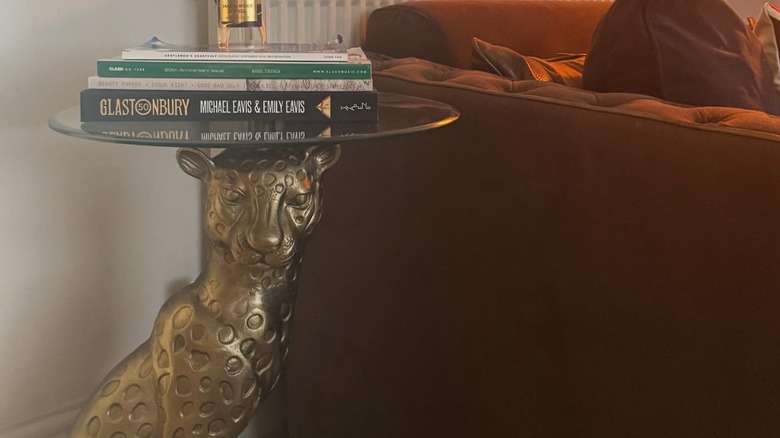 A golden leopard coffee table with books on top.
