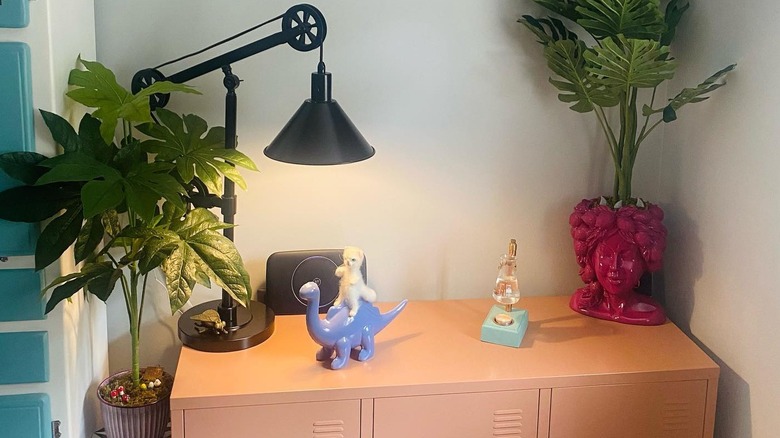 Several knick-knacks and a black lamp on a wood table.