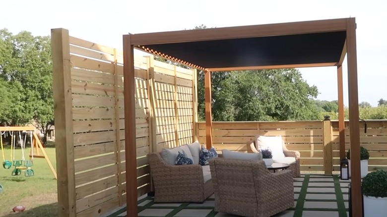 Wooden awning covering a patio with chairs